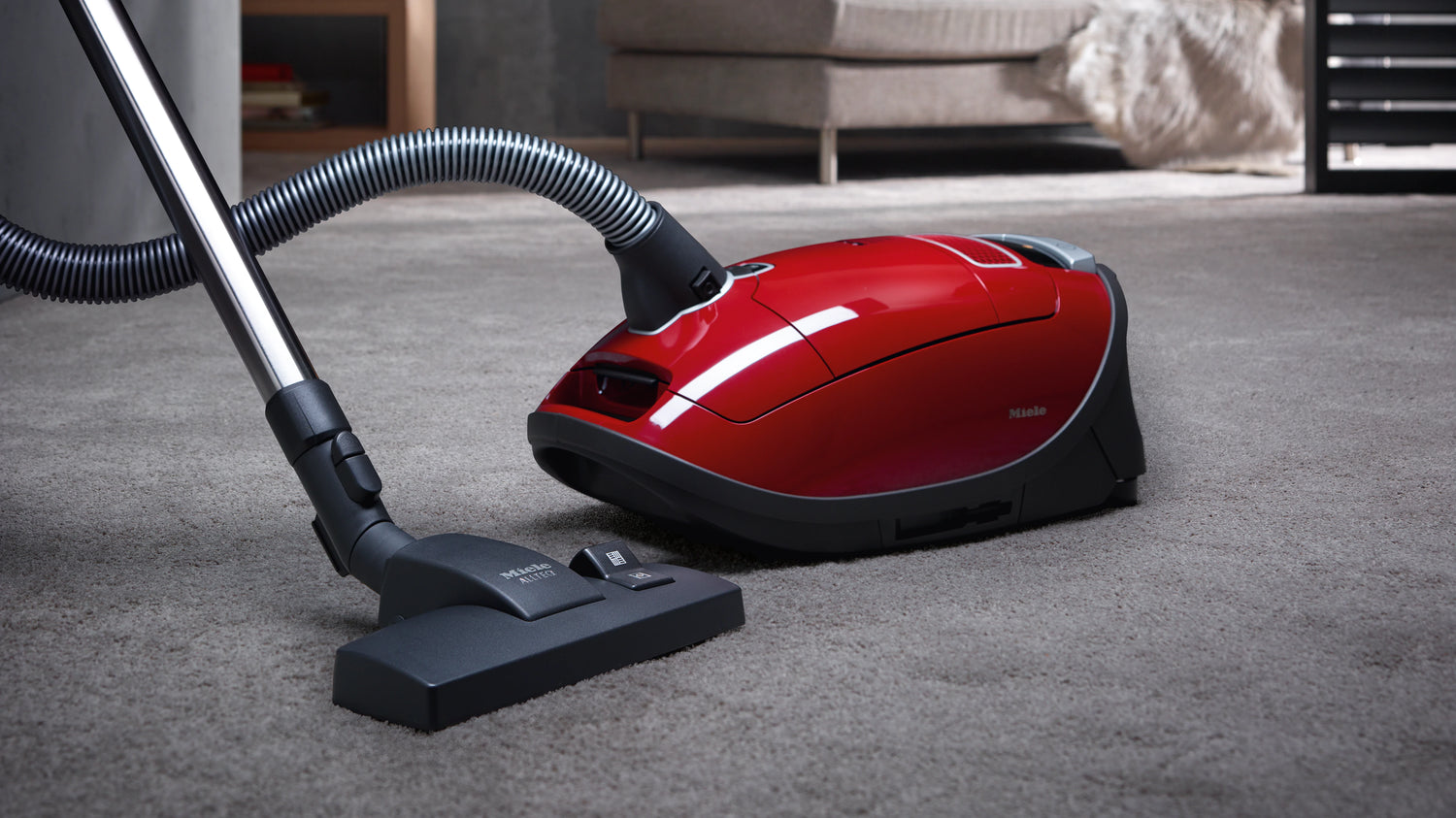 Red Miele Vacuum Cleaner with carpet and floor attachment